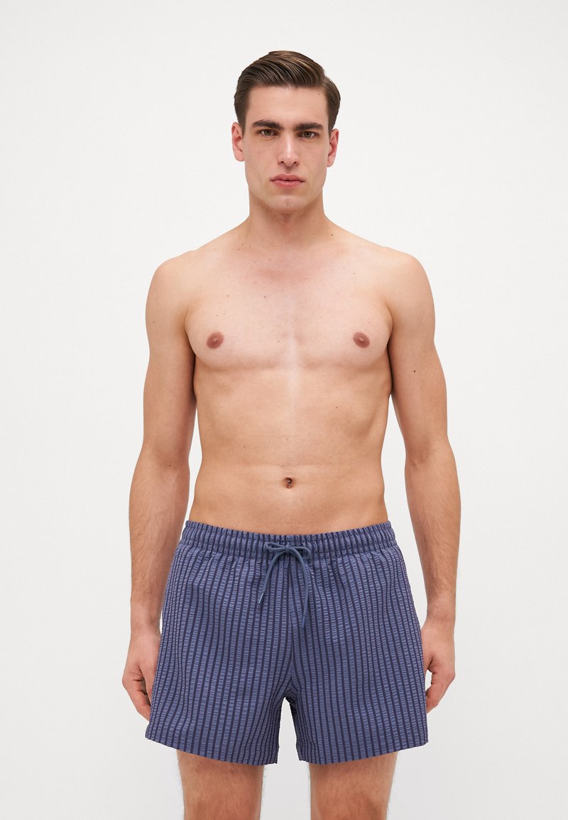 Menns navy badebukser med teksturert stripete design, elastisk midje, justerbar snor og avslappet passform.