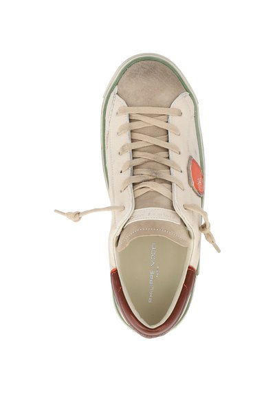 Sneaker beige con punta in suede color cammello, bordo verde della suola, dettaglio marrone sul tallone, patch arancione di lato e lacci annodati, vista dall'alto.