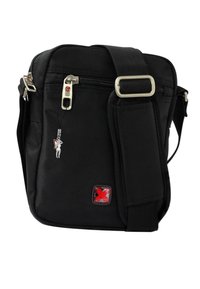 Zwarte nylon schoudertas met een voorzak met rits, zilveren hardware, rode accenten en een klein charm-detail. Compacte en rechthoekige vorm.