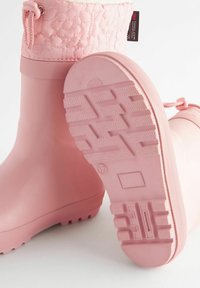 Botas de lluvia de goma impermeables de color rosa con un diseño floral acolchado en la parte superior, suela texturizada con una banda de rodadura con patrón para mejorar el agarre.