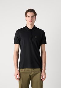 Black polo shirt with a three-button placket, short sleeves, and a textured fabric. Features a small, embossed logo on the chest.
