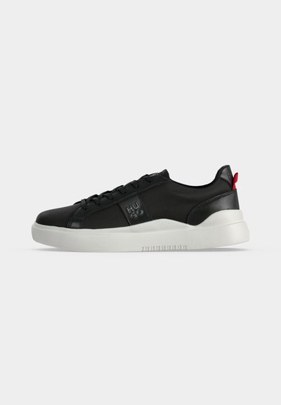 Baskets basses noires avec semelle blanche, lacets à l'avant, logo "HUGO" sur le côté, et languette rouge au talon.