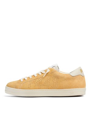 Beiger Low-Top Sneaker aus Wildleder mit weißen Schnürsenkeln, perforiertem seitlichem Design, weißer Sohle und weißem Fersenlasche mit goldener Beschriftung.