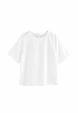 Blouse blanche unie à manches courtes avec un col rond et une coupe ample légèrement raccourcie sur fond blanc.