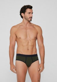 Tmavě zelené pánské slipy s modrým elastickým pasem, které mají švové detaily. Tkanina vypadá jemně a dobře padne, vhodná pro každodenní nošení.