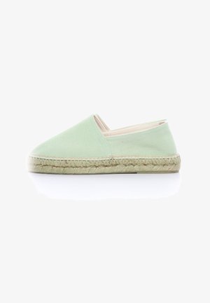 Espadrille en toile verte avec un bout fermé et un côté élastique, dotée d'une semelle en jute naturel et de coutures le long du bord.