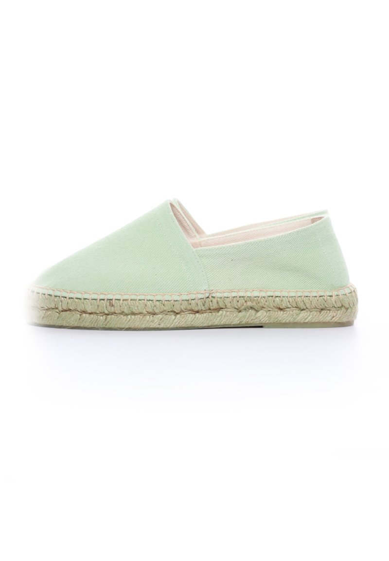 Espadrille en toile verte avec un bout fermé et un côté élastique, dotée d'une semelle en jute naturel et de coutures le long du bord.