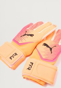 Rękawice bramkarskie PUMA z pomarańczowym podbiciem i gradientowym różowym wzorem, akcenty logo w kolorze czarnym oraz teksturowany uchwyt dla lepszej kontroli.