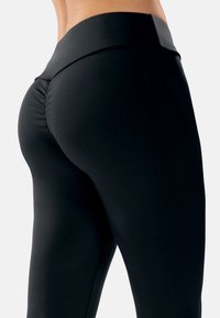 Zwarte leggings van rekbaar materiaal, met een hoge taille en een geplooide accent aan de achterkant voor een aansluitende uitstraling.