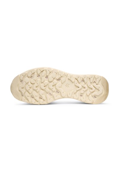 Suola beige chiaro con gomma testurizzata, caratterizzata da un modello di battistrada multidirezionale per grip e stabilità. Punta arrotondata con leggero arco.