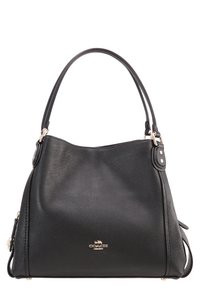 Sac à main en cuir noir Coach avec deux anses, surface texturée et ferrures argentées, affichant le logo de la marque au centre devant.