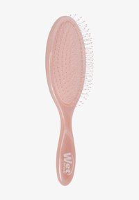 Wet Brush haarborstel in doorschijnend roze kunststof, ovale vorm met flexibele haren en een gestructureerde handgreep. Bevat het logo in het wit nabij de basis.