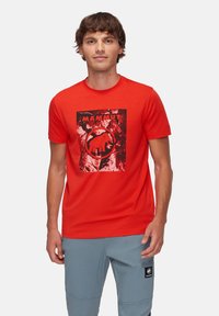 Röd koton T-shirt med en svart grafisk bild av en mammut och logotyp på framsidan. Rund hals och korta ärmar.