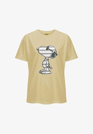 T-shirt beige à manches courtes avec une illustration en profil de Snoopy portant des lunettes de soleil avec des rayures horizontales grises et blanches.