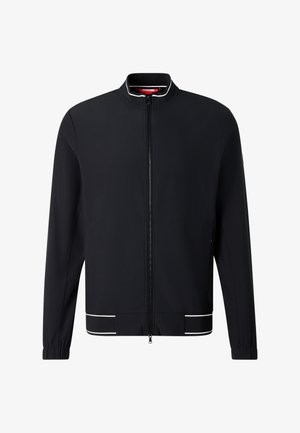 Schwarze Jacke mit durchgehendem Reißverschluss, Stehkragen, elastischen Bündchen und weißen Verzierungen am Kragen und Saum.