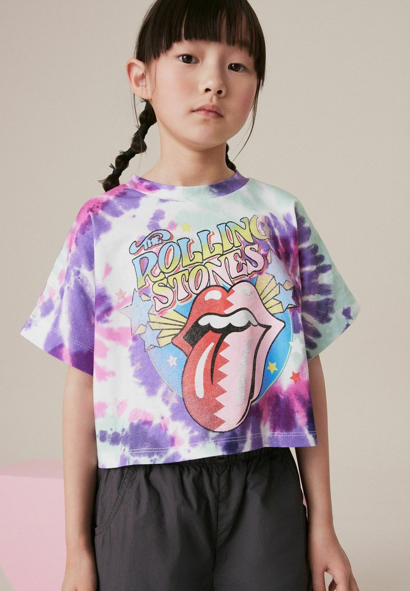 Kruopēta T-kreklu ar raibs zīmējums, kas ietver rozā, violetas un zaļas krāsas. Priekšā ir krāsains "Rolling Stones" logotips ar mēli.