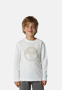 T-shirt bianco a maniche lunghe in cotone con un logo circolare beige che presenta la scritta "NORTH SAILS" e le lettere "N" e "S" sul davanti.