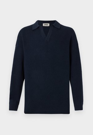 Tumed ribane särk, millel on V-kaelus, lühike krae ja pikad varrukad. Valmistatud pehmest materjalist, millel on tekstuuriga viimistlus.