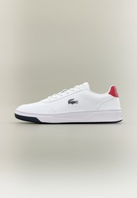 Λευκά συνθετικά αθλητικά παπούτσια με χαμηλό προφίλ, σχέδιο με κορδόνια και ναυτική ελαστική σόλα. Διαθέτουν κόκκινη λεπτομέρεια στη φτέρνα και κεντητό λογότυπο.