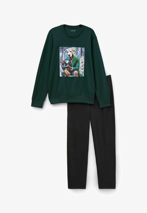 Grüner Sweatshirt mit einem bedruckten Grafik eines Hundes in einem Anzug, der ein Getränk hält; kombiniert mit schwarzen Hosen, beide aus einem weichen Material hergestellt.