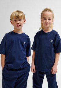 Marinblå bomullströjor med kort ärm och rund halsringning; har en liten dekorativ logotyp på vänster bröst.