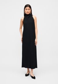 Μαύρο αμάνικο μάξι φόρεμα με ψηλό λαιμό, κατασκευασμένο από λείο ύφασμα· διαθέτει απλό, λιτό σχέδιο με σιλουέτα Α-γραμμή.