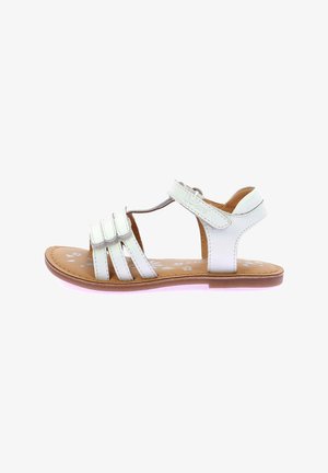 Sandalias de cuero blanco con múltiples correas, hebilla ajustable y plantilla de color marrón con un patrón floral. Suela plana con un ligero acento rosa.