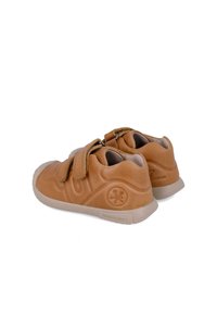 Zapatos de cuero marrón con dos correas de Velcro, punta redondeada, acentos texturizados y una suela de goma ligera. Nombre de la marca estampado en el lateral.