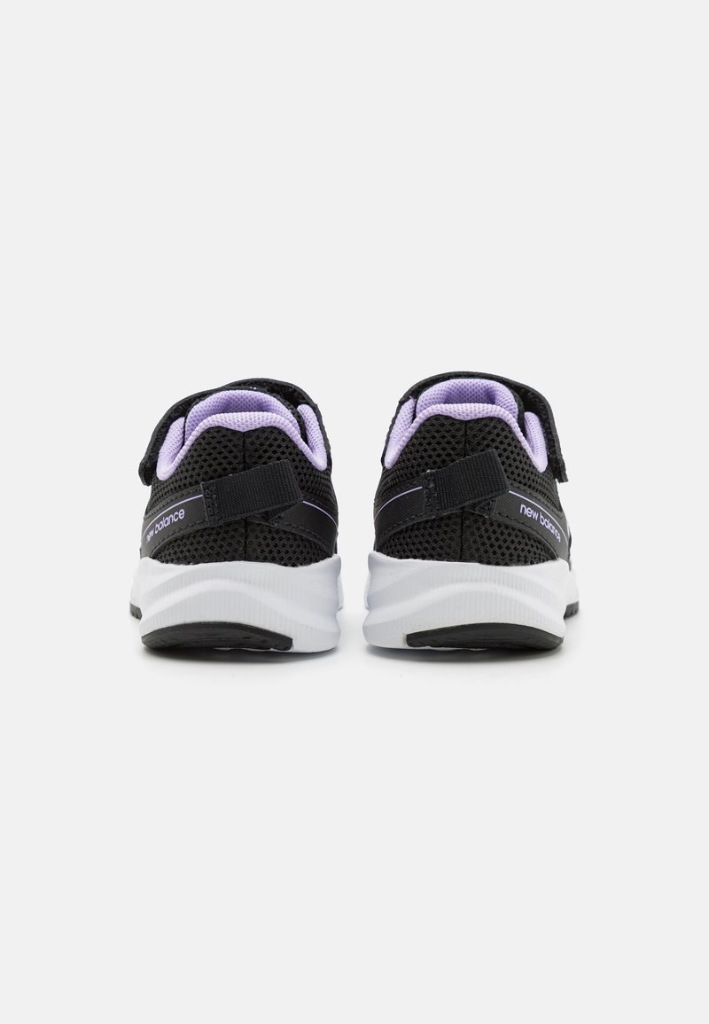 Zapatillas deportivas negras con parte superior de malla, acentos morados y suelas blancas resistentes. Correas ajustables para un ajuste seguro y suela negra plana.