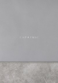 Gray leather laptop sleeve with a smooth texture. Features embossed "EXPATRIÉ" logo and a contrasting textured gray bottom panel.