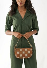 Sac à main marron à motif en cuir, présentant un design tissé avec une bandoulière en chaîne dorée. Forme rectangulaire, surfaces lisses et texturées.