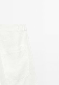 White linen pants with a waistband, single back pocket, and subtle texture. The design is minimalistic and tailored for a loose fit.