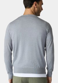Maglione grigio a maniche lunghe con texture liscia, orlo e polsini a costine. Mostrato da dietro, indossato sopra una camicia bianca.