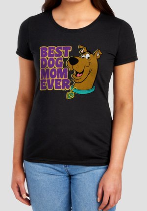 Black t-shirt with cartoon Scooby-Doo head and purple text reading "BEST DOG MOM EVER" worn by person in blue jeans.