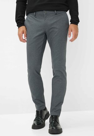 Graue gemusterte Hose aus leichtem Stoff, mit schmaler Passform, Knopfverschluss und kombiniert mit schwarzen Schuhen.