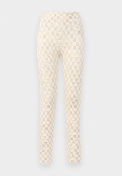 Leggings met een aansluitend ontwerp, voorzien van een crèmekleurige basis en een herhalend beige geometrisch patroon. Gemaakt van een gladde, rekbare stof.