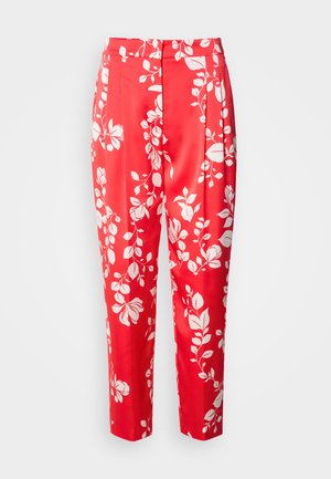 Pantalons rouges en tissu lisse avec un motif floral blanc. Ils ont une coupe ajustée avec une taille haute et une longueur cropped.