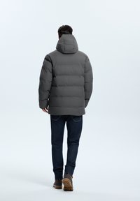 Gray padded jacket with a hood, featuring a smooth texture and horizontal quilted pattern, paired with blue jeans and brown footwear.