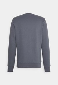 Mörkgrå långärmad sweatshirt med ribbad mudd och fåll, visad från baksidan mot en vit bakgrund.