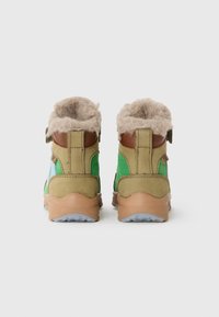 Zapatos altos verdes y beiges con forro de piel sintética marrón, materiales de gamuza texturizada y malla, y acentos marrones, con una suela de goma moldeada.
