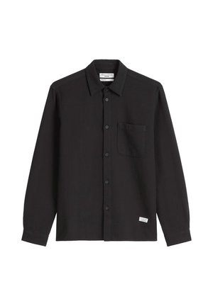 Black long-sleeve button-up shirt in textured fabric, featuring a front pocket and tag detail at the hem. Standard collar and button closure.