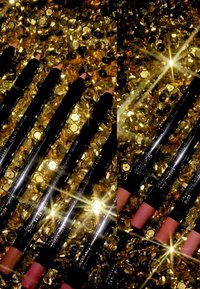 Collezione di sei matite per labbra con fusto nero, esposte su uno sfondo di paillettes dorate lucide. Vari colori, tra cui nudo e malva.