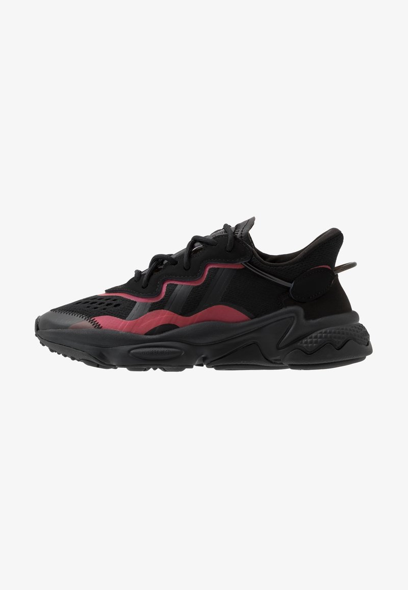 Black and maroon athletic shoe with mesh and rubber materials, rounded toe, wavy design accents, thick sole with textured grip.