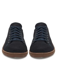 Adidași din suede navy cu vârful rotund, talpă din cauciuc maro și șireturi albastre contrastante. Au un modic de cusături și detalii cu gauri.