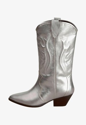 Silver metallic cowboy boot with pointed toe, decorative stitching, and a low stacked heel. Features a pull tab at the top for easy wear.