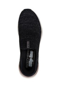 Zapato negro tipo slip-on con parte superior de punto texturizado, diseño elástico, plantilla acolchada y suela de goma blanca. Incluye etiquetas de la marca en el interior.