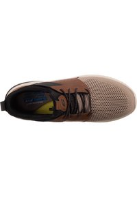 Hnědo-beige sportovní bota s síťovaným svrchním materiálem, koženými akcenty, kulatými tkaničkami a texturovanou podrážkou. Obsahuje logo "S" a polstrovaný límec.