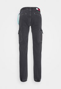 Black cargo pants with back pockets, side flap pockets, elastic cuffs, and a red, white, and blue brand label on the waistband.