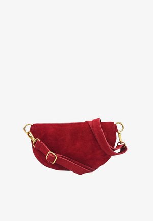 Sac bandoulière demi-lune en daim rouge avec sangle réglable et fermoirs ainsi que boucle en métal doré sur fond blanc.