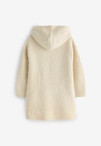 Manteau crème à capuche en tissu texturé et duveteux. Il possède des manches longues et une capuche réglable, conçu pour le confort et la chaleur.